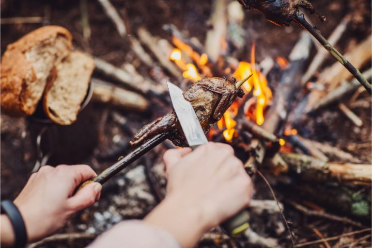“Carving wood for fire with survival knife in wilderness”