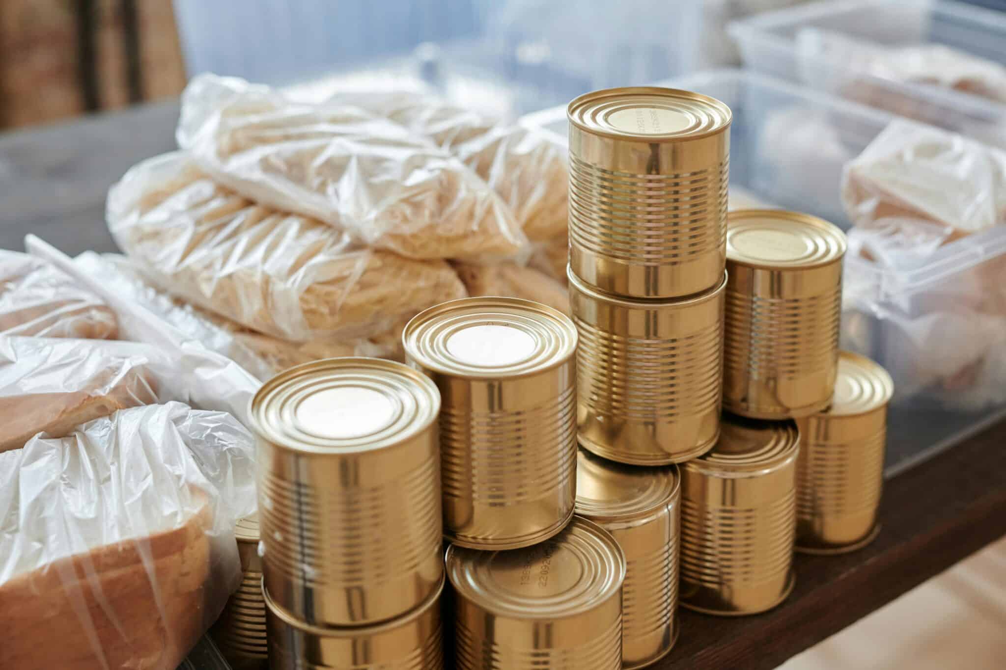 stacked canned food and packaged dry goods prepared for apartment emergency food storage in plastic containers