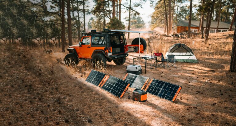 Grid-down survival camp setup with portable solar panels and backup power station for off-grid emergency power.