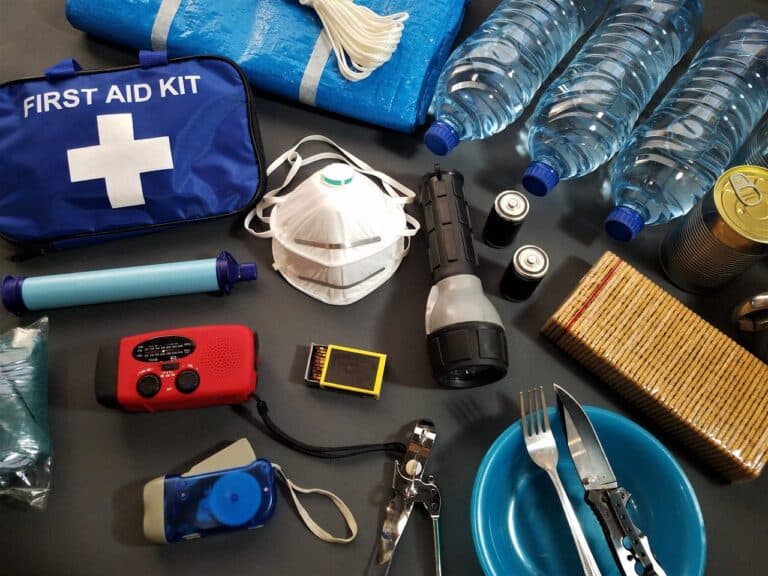 essential emergency preparedness supplies including first aid kit, water bottles, flashlight, radio, and food for disaster readiness