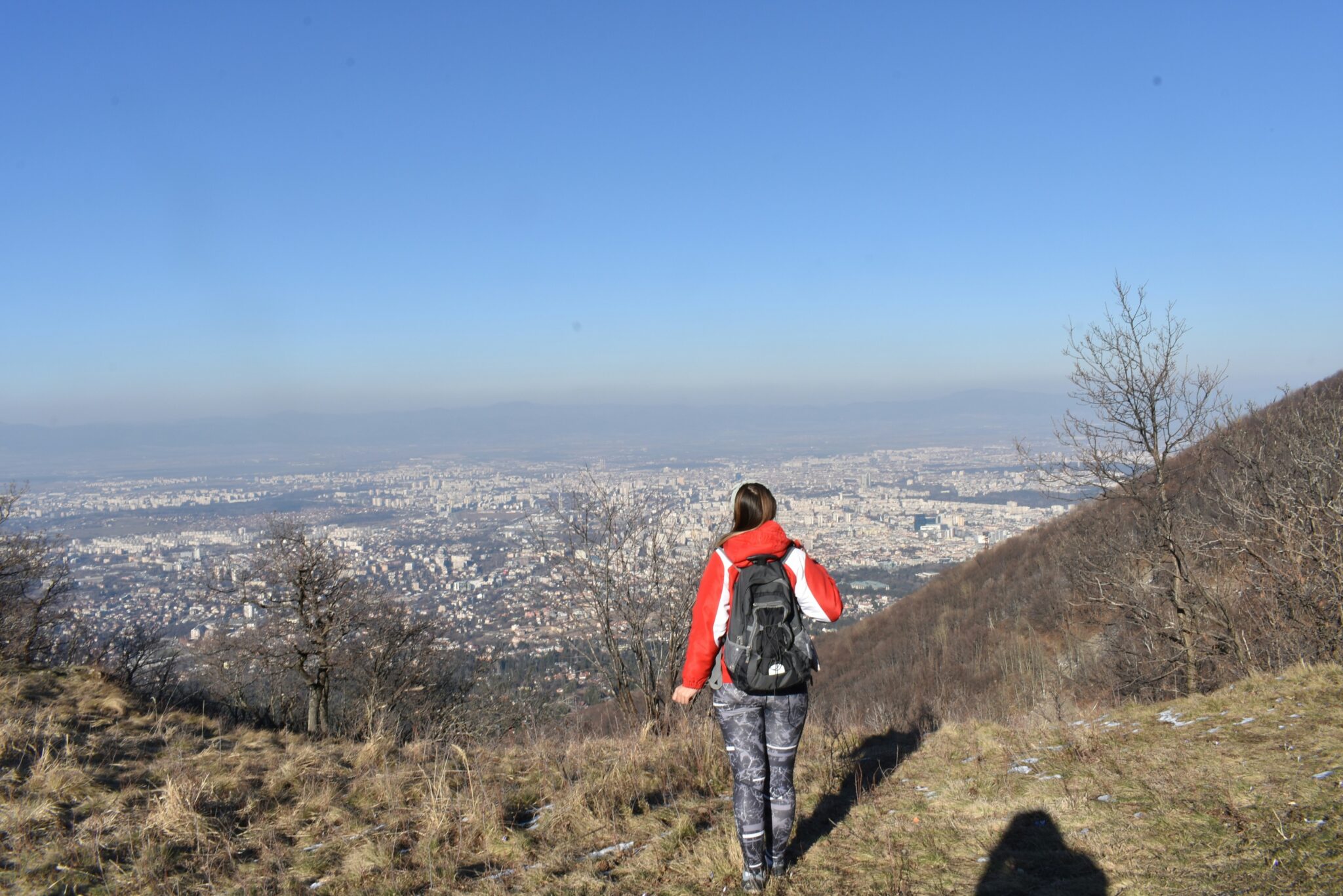 person walking away from city toward rural bug out location with backpack